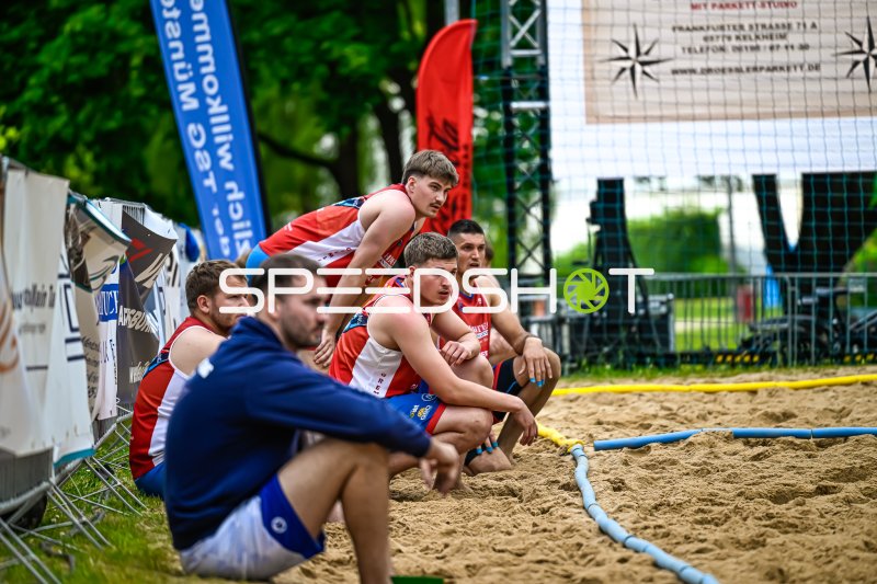 Beachhandball-Spieler beobachten das Spielgeschehen vom Spielfeldrand