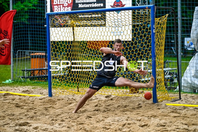 Torwart pariert Ball im Sand beim Beach-Handball