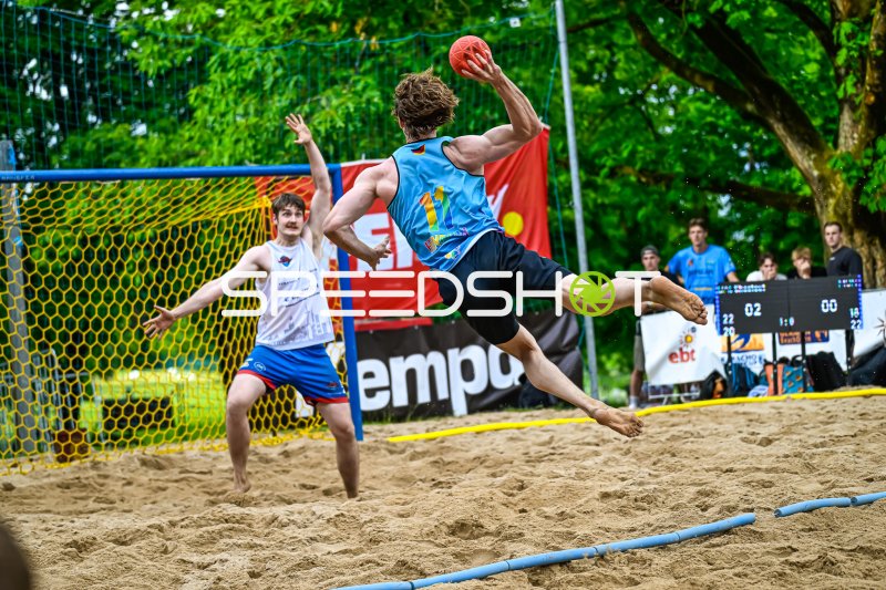 Spieler #11 beim Wurfversuch im Beach-Handball-Turnier