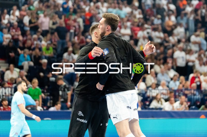 Zwei THW-Kiel-Spieler umarmen sich an der Seitenlinie