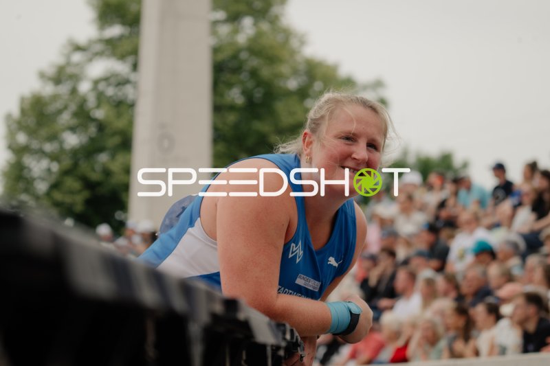 Athletin im blauen Trikot lächelt bei Leichtathletik-Wettkampf