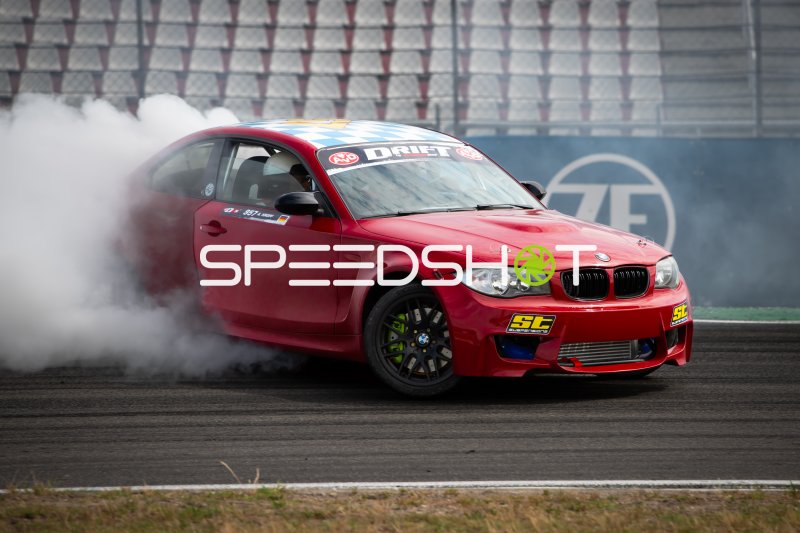 BMW 1er M Coupé #957 driftet mit starker Rauchentwicklung auf der Rennstrecke