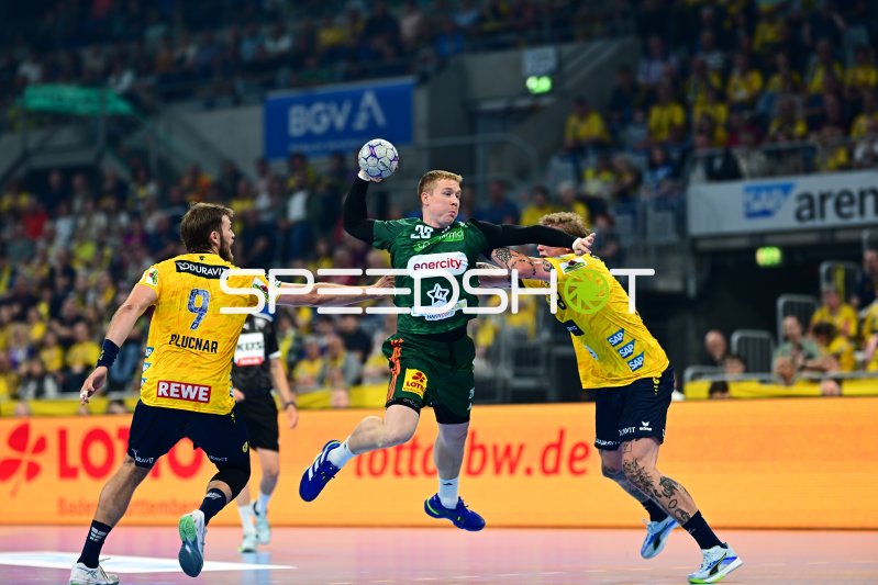 Bendix Dietzsch (#20; TSV Hannover-Burgdorf) im Sprungwurf zwischen zwei Löwen-Abwehrspielern