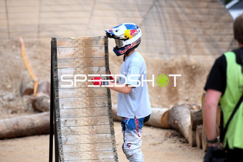 Fahrer mit Red Bull Helm inspiziert Holzrampe beim Erzbergrodeo 2026