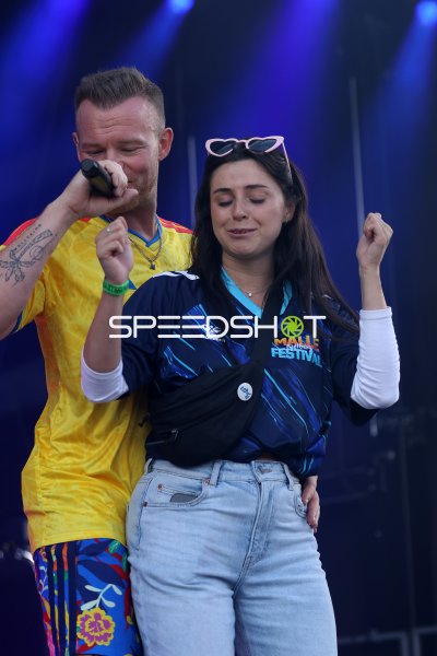 Live-Act mit Mikrofon und Zuschauerin auf der Bühne beim Malle Rietberg Festival
