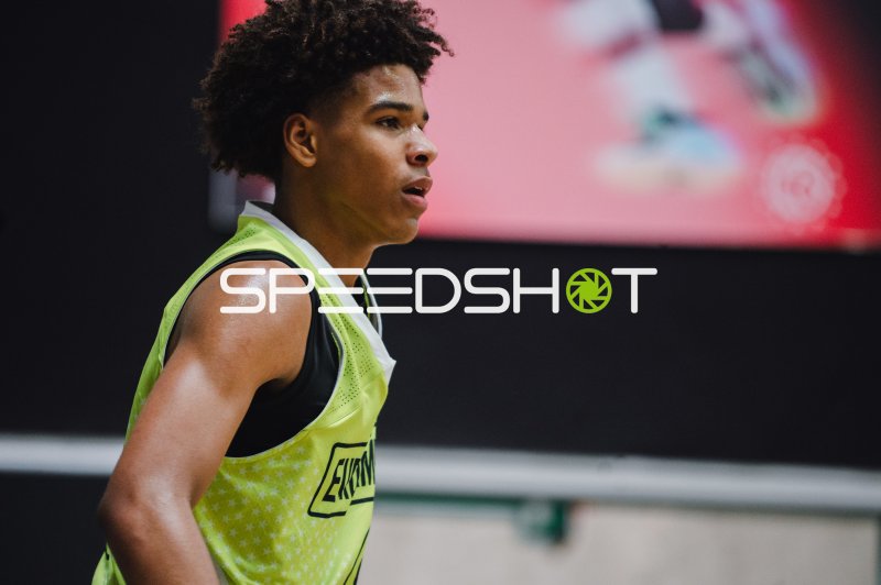 Basketballspieler im Neongelben Trikot beobachtet das Spielgeschehen