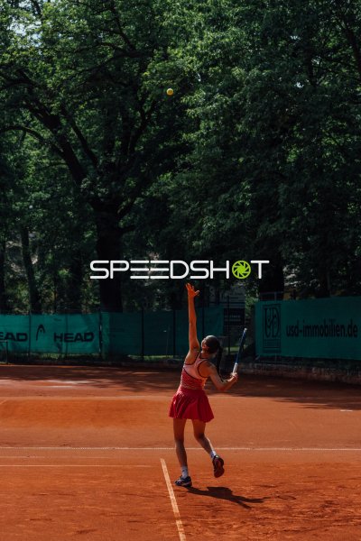 Weitwinkelaufnahme von Tennisspielerin Sophie Roden beim Aufschlag auf dem Sandplatz in Dresden