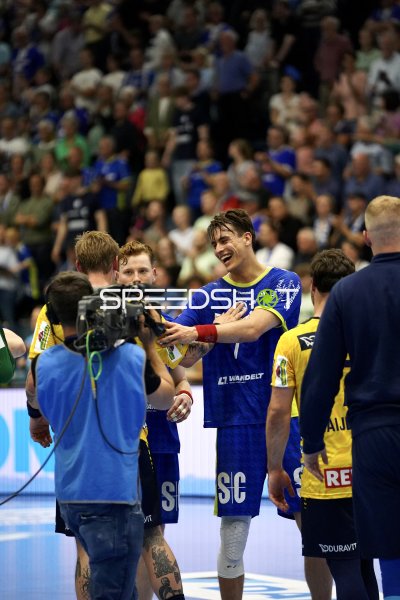Julian Köster (VfL Gummersbach) jubelt vor TV-Kamera nach Spielende