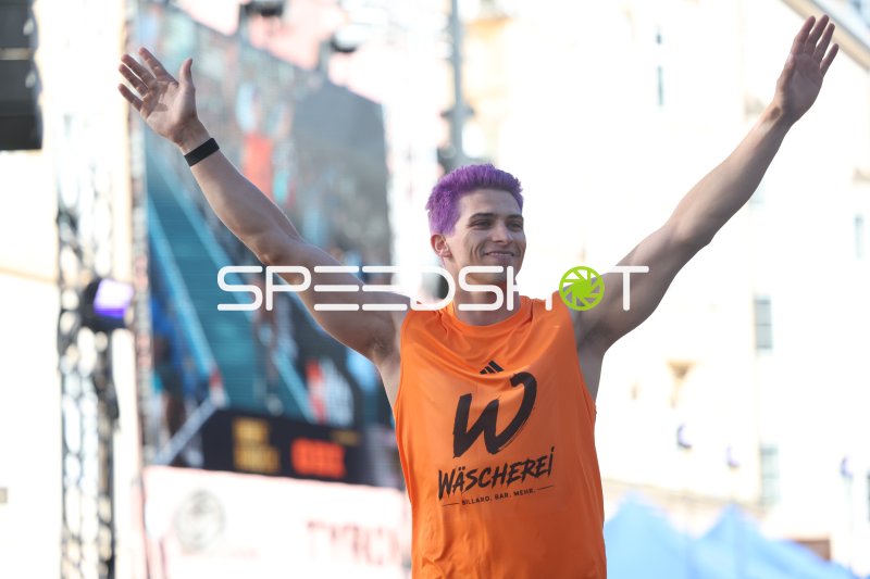 Athlet mit lila Haaren jubelt beim Weitsprung-Event in Innsbruck