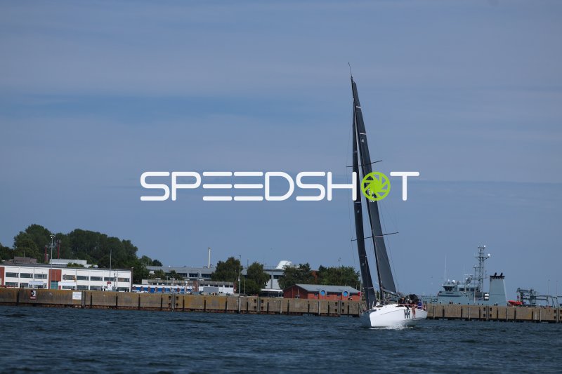 Segelboot mit dunklem Großsegel im Hafen Eckernförde