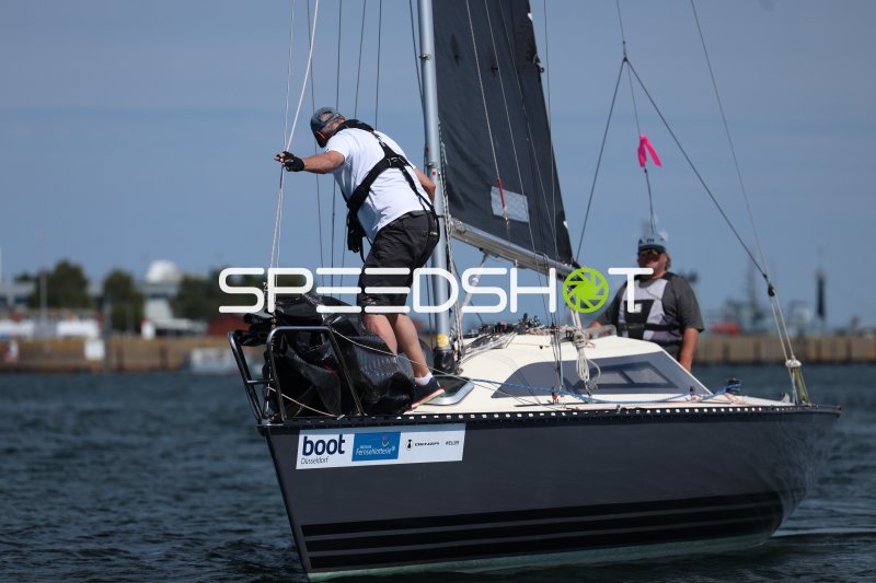 Segelboot mit zwei Crewmitgliedern im Hafen Eckernförde