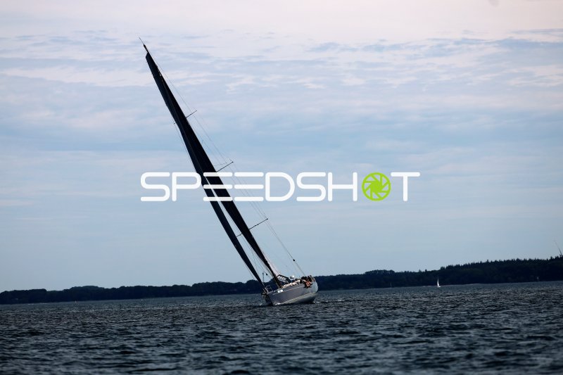 Segelboot mit schwarzem Großsegel bei starker Krängung auf der Eckernförder Bucht