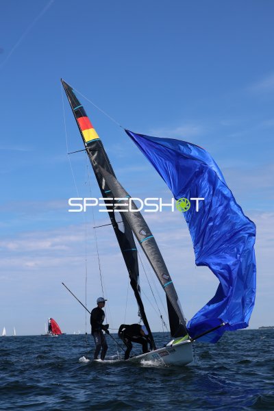 Segelboot mit blauem Spinnaker bei Manöver auf der Kieler Förde