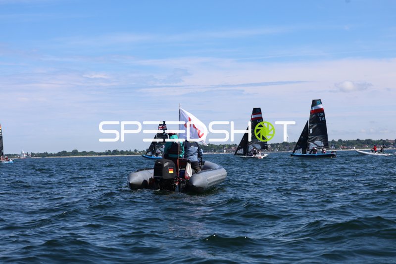Schlauchboot mit Flagge begleitet FX-Segelregatta in Schilksee