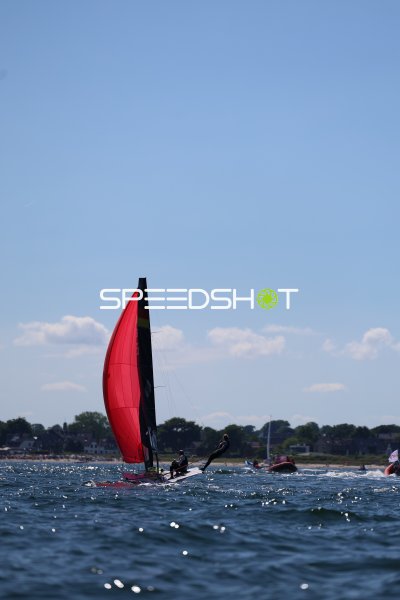 Segelboot mit rotem Spinnaker bei Regatta vor Schilksee