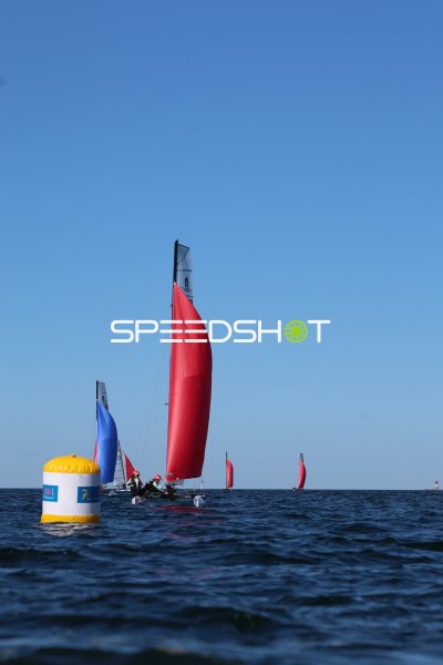 Segelboote mit roten Spinnakern runden Tonne bei Regatta in Kiel