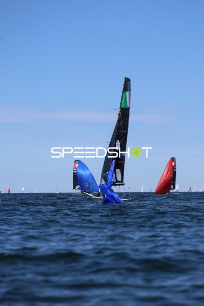 Segelboot kentert mit blauem Spinnaker bei Regatta in Kiel