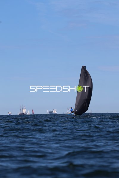 Segelboot mit schwarzem Spinnaker auf der Kieler Förde